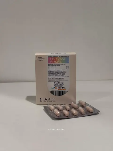 กล่อง Dr.Aum Liposomal Vitamin C+ สีชมพูอ่อน ฉลากแถบสีรุ้ง ตั้งบนโต๊ะสีขาว ข้างหน้ามีแผงแคปซูลสีชมพู 10 เม็ด