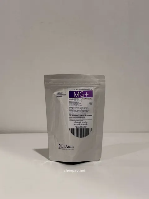ซองซิปสีเงิน Dr.Aum MG+ ฉลากขาวแถบม่วง ระบุ Magnesium + Vitamin D3K2 บรรจุ 30 แคปซูล ตั้งบนโต๊ะสีขาว